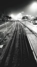 Railroad tracks against sky at night