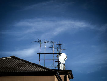 Low angle view of communications tower against blue sky