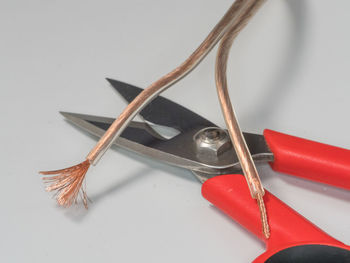 High angle view of electric cables and scissors on gray background