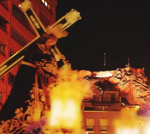 Low angle view of illuminated buildings against sky at night