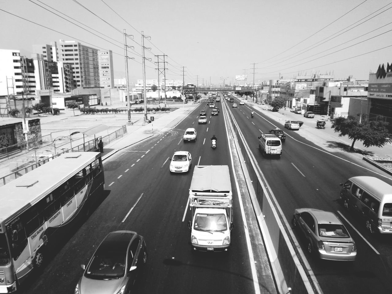 transportation, car, mode of transport, land vehicle, road, traffic, city, street, on the move, road marking, the way forward, built structure, architecture, building exterior, diminishing perspective, city life, travel, highway, city street, clear sky