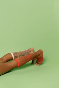 Close-up of hand holding leaf against white background