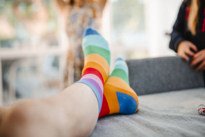 Low section of legs in striped rainbow socks