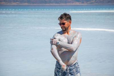 Young man standing on beach