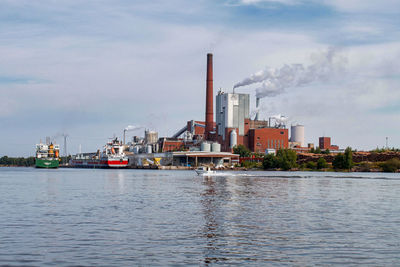 River by factory against sky