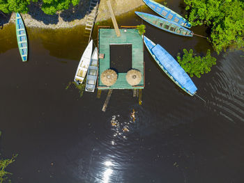 Aerial top view of a small wooden pier and some conoes in the amazon river in the forest in brazil