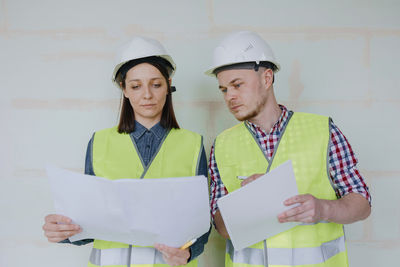 Engineers holding plans at construction site