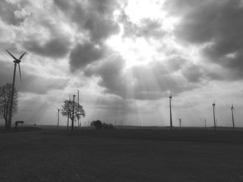 Wind turbines on field against sky