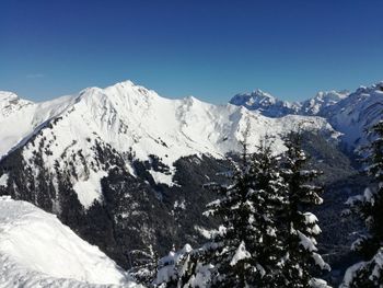 Scenic view of snowcapped mountains against clear blue sky