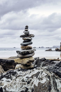 Stack of rocks on beach against sky