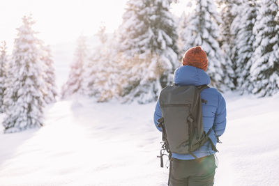 Rear view of woman standing on snow