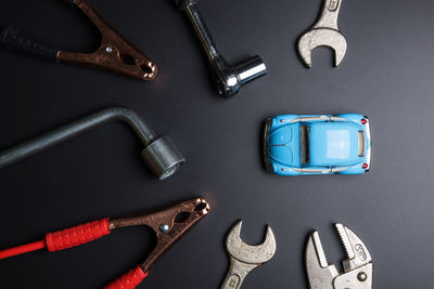 Directly above view of hand tools with toy car on gray background