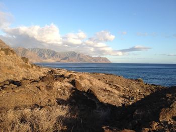 Scenic view of sea and mountains against sky