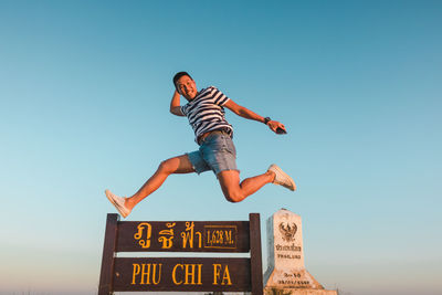 Low angle view of person paragliding against sky