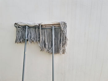 Used mops for housekeeping lean against old dirty wall