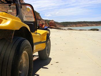 Vintage car on beach against sky