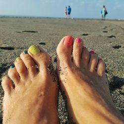 Low section of woman standing on beach