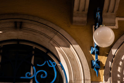 Low angle view of illuminated lamp hanging on ceiling of building