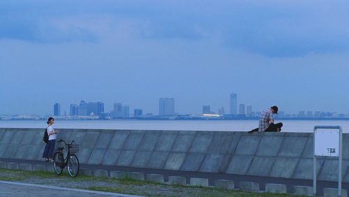 Man with bicycle on sea in city