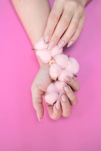 Close-up of woman hand holding pink petals