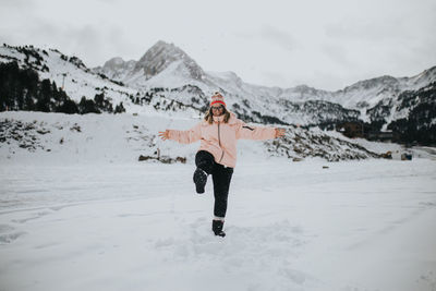 Full length of woman on snowcapped mountain against sky