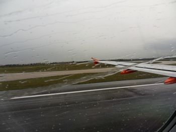 Airplane seen through wet glass window