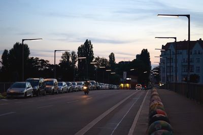 Cars on road in city against sky