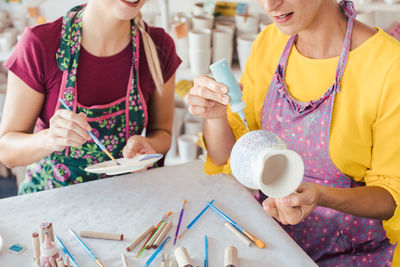 Midsection of woman holding hands on table