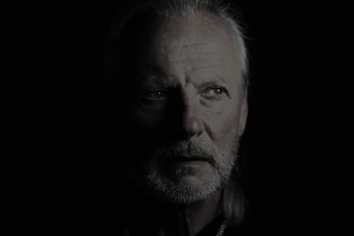 Portrait of man against black background