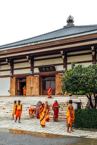 Group of people outside temple against building