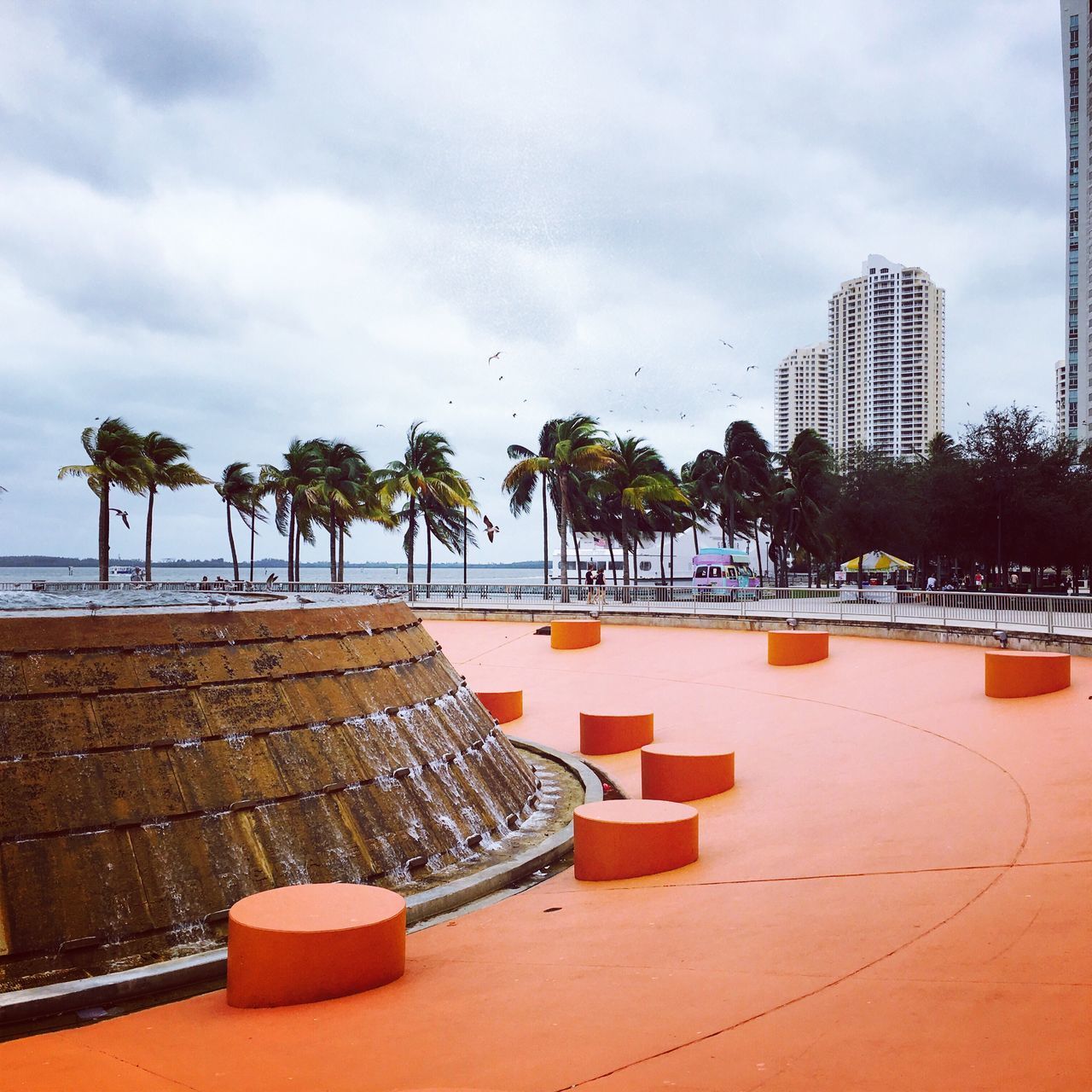 LOUNGE CHAIRS BY SWIMMING POOL AGAINST BUILDINGS