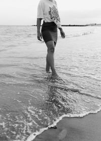 Low section of man standing on beach