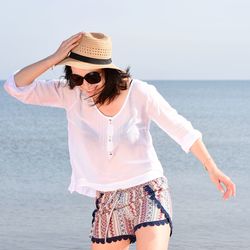 Portrait of young woman against sea