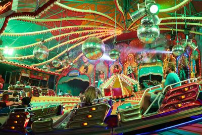 People in amusement park ride at night