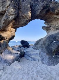 Rock formation by sea against sky