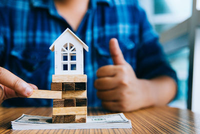 Midsection of man holding small glass of building