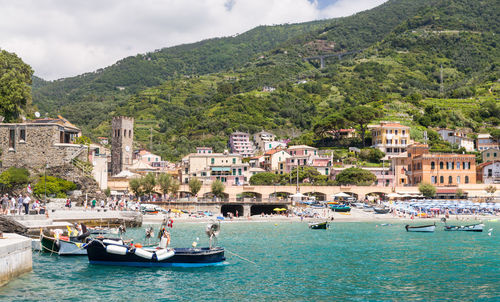 Boats in sea against buildings in city