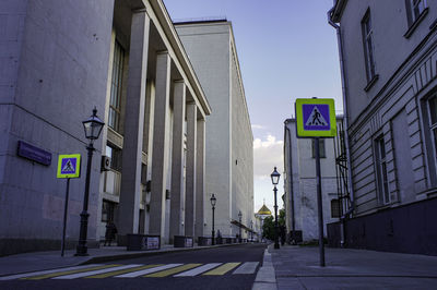 Road sign on street against buildings in city