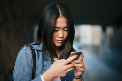 Teenage girl using smart phone in city