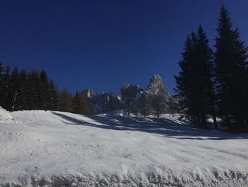 Scenic view of snow covered landscape against clear blue sky