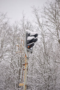 Low angle view of road sign on snow covered landscape