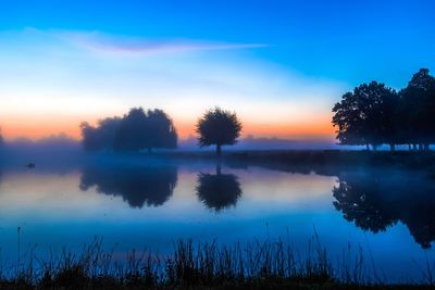 Scenic shot of calm lake at sunset