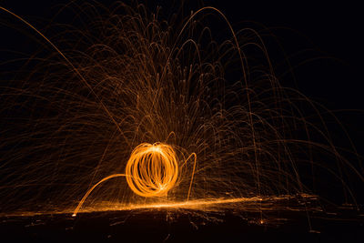 Person spinning wire wool at night