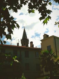 Low angle view of trees and building against sky