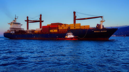 Commercial dock by sea against clear sky