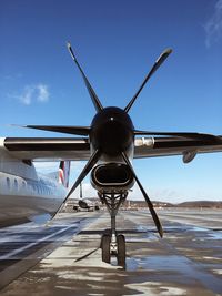 Airplane on airport runway against blue sky