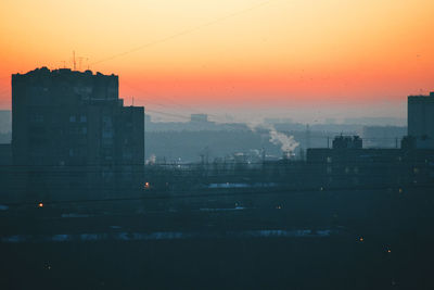 Silhouette buildings against sky during sunset in city