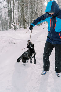 Rear view of man skiing on snow covered field