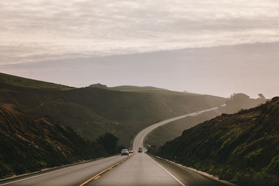 Road passing through mountain against sky