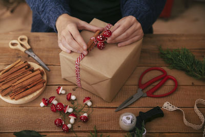 Woman's hands decorating christmas present